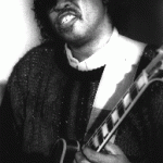 Photograph of Clarence Brown playing a guitar